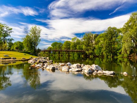 Friedliche Szenerie der Augartenbucht in Graz mit Bäumen und Wasserreflektion. | © Graz Tourismus - Harry Schiffer
