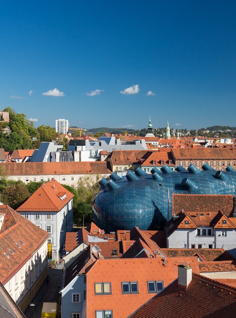 Blick auf die malerische Dachlandschaft von Graz, das Kunsthaus und den Grazer Uhrturm. | © Graz Tourismus - Harry Schiffer