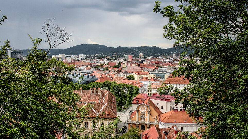 Vista panoramica di Graz che mostra i tetti rossi e il Kunsthaus. | © Angelika Schwaff_Reisefreunde