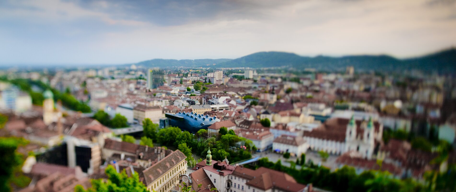 Luftaufnahme von Graz mit Blick auf die Dachlandschaft und das Kunsthaus Graz. | © Graz Tourismus - Harry Schiffer