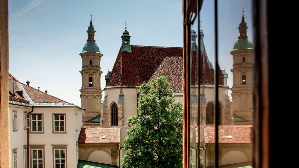 Blick auf den Grazer Dom zwischen Gebäuden und Bäumen. | © Angelika Schwaff_Reisefreunde