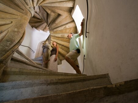 Ein Paar geht die berühmte Doppelwendeltreppe in Graz hinauf. | © Graz Tourismus - Hans Wiesenhofer