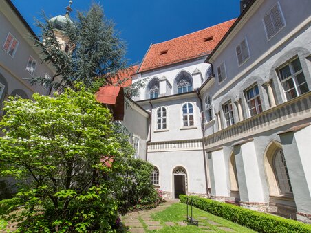 Vista del Chiostro di San Francesco a Graz con giardino e edifici. | © Graz Tourismus - Harry Schiffer