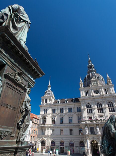 View of the town hall at Hauptplatz in Graz with statues in the foreground. | © Graz Tourismus - Harry Schiffer