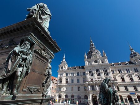 Vista del municipio in Hauptplatz a Graz con statue in primo piano. | © Graz Tourismus - Harry Schiffer