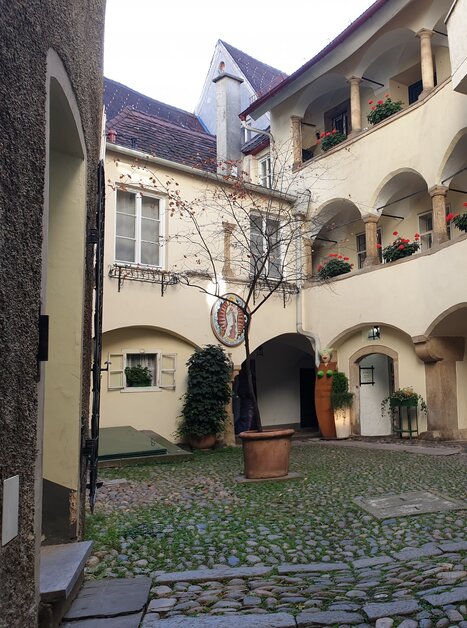 Un cortile pittoresco con piante, archi e una bicicletta. | © Gudrun Krinzinger - Reisebloggerin