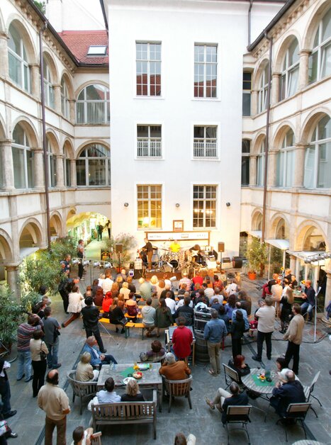 Cortile affollato con persone e una band durante un evento. | © Graz Tourismus - Harry Schiffer