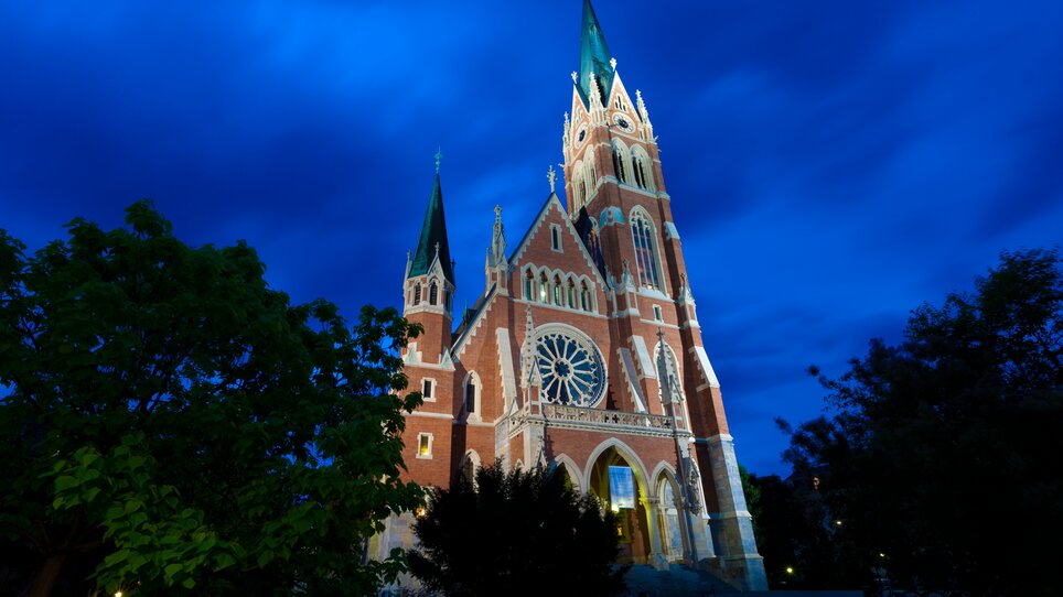 Stylish church with ornate details under a cloudy night sky. | © Graz Tourismus - Harry Schiffer