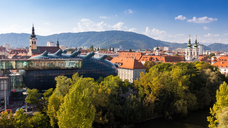 Blick auf das Grazer Kunsthaus mit der Stadt im Hintergrund.