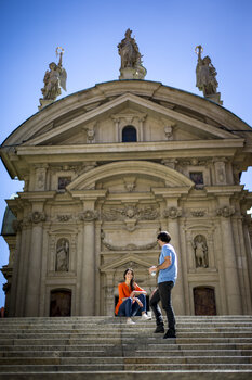 Paar sitzt auf Treppen vor dem beeindruckenden Mausoleum in Graz. | © Graz Tourismus - Tom Lamm