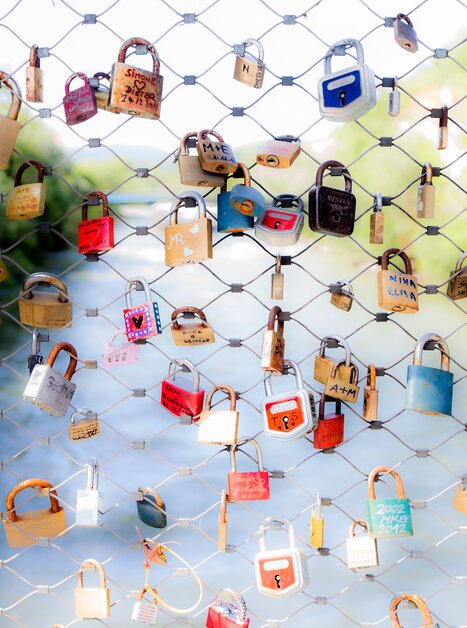 Farbenfrohe Schlösser hängen an einem Zaun nahe der Mur. | © Graz Tourismus - Harry Schiffer