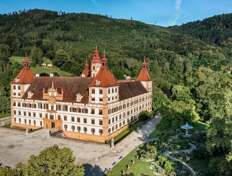 Luftbild des Schlosses Eggenberg in Graz, umgeben von grüner Landschaft. | © Graz Tourismus - Mias Photoart