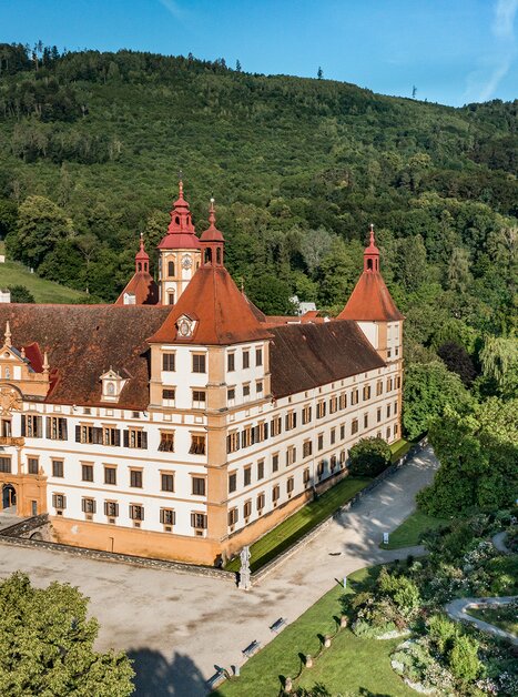 Luftbild des Schlosses Eggenberg in Graz, umgeben von grüner Landschaft. | © Graz Tourismus - Mias Photoart