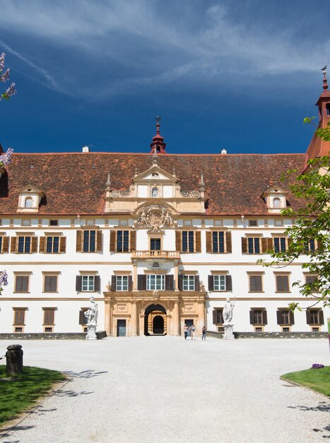Il maestoso Castello di Eggenberg a Graz, circondato da fiori e alberi. | © Graz Tourismus - Harry Schiffer