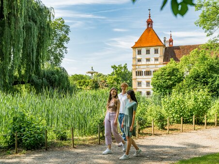 Three people walking in the park around Eggenberg Palace in Graz. | © Graz Tourismus - Mias Photoart