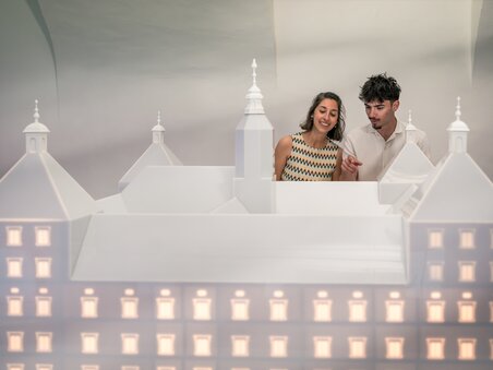 A couple looks at a large architecture model. | © Graz Tourismus - Mias Photoart