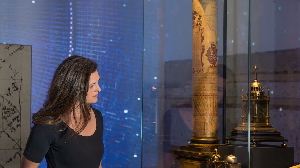 Eine Frau bewundert einen historischen Turm in einer Ausstellung. | © Graz Tourismus - Mias Photoart