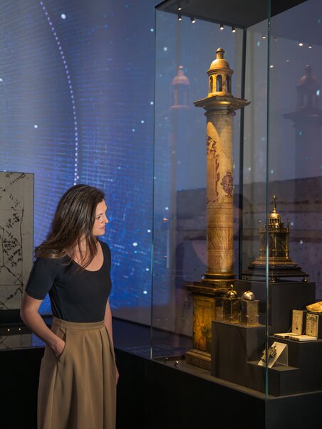 Eine Frau bewundert einen historischen Turm in einer Ausstellung. | © Graz Tourismus - Mias Photoart