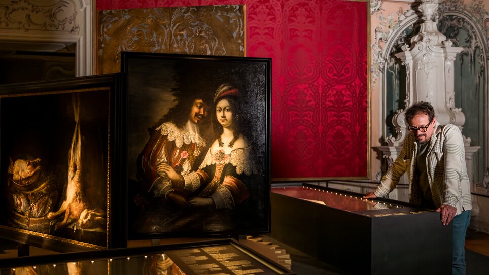 Ein Mann betrachtet Gemälde im Schloss Eggenberg. | © Graz Tourismus - Mias Photoart