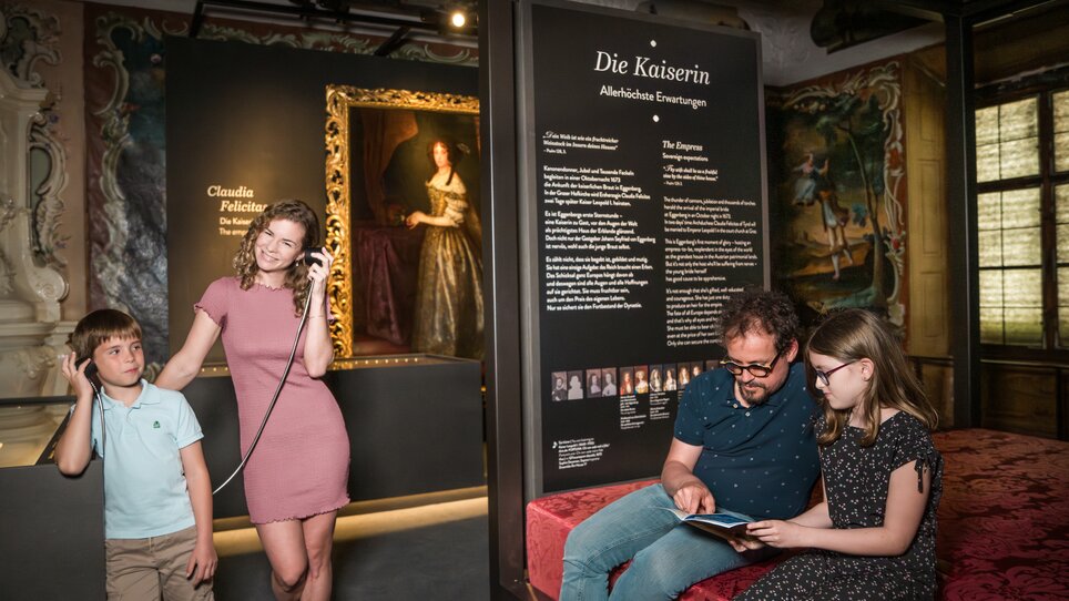 Familie betrachtet Kunst im Schloss Eggenberg, hört Infos über Kaiserin. | © Graz Tourismus - Mias Photoart