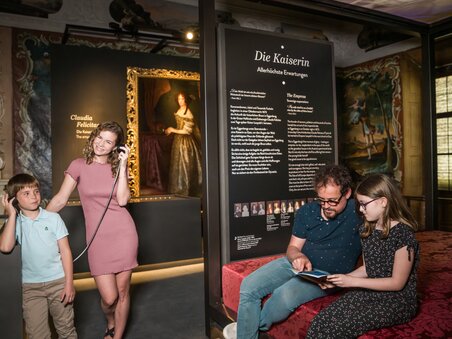 Familie betrachtet Kunst im Schloss Eggenberg, hört Infos über Kaiserin. | © Graz Tourismus - Mias Photoart