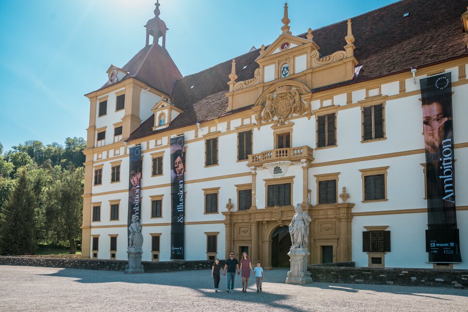 Eggenberg Palace – SHOWING STYRIA 2025 | © Graz Tourismus - Mias Photoart Visitors in front of a creative castle featuring large banners. | © Graz Tourismus - Mias Photoart