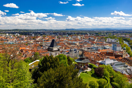 Panoramic view over Graz featuring the Graz Clock Tower, the Chinese Pavilion, the beautiful rooftop landscape, and the Graz City Hall. | © Graz Tourismus - Harry Schiffer
