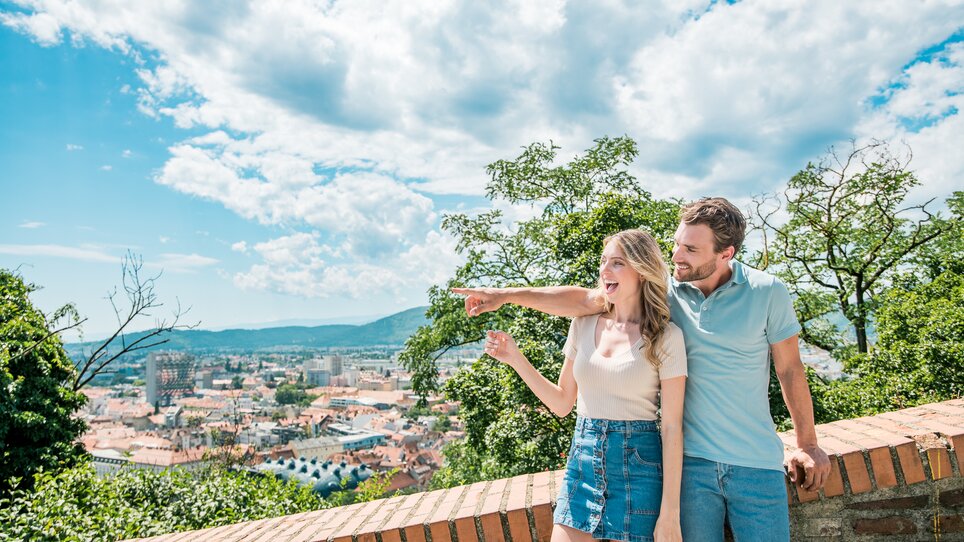 Paar genießt den Ausblick über Graz vom Schlossberg. | © Graz Tourismus - Mias Photoart