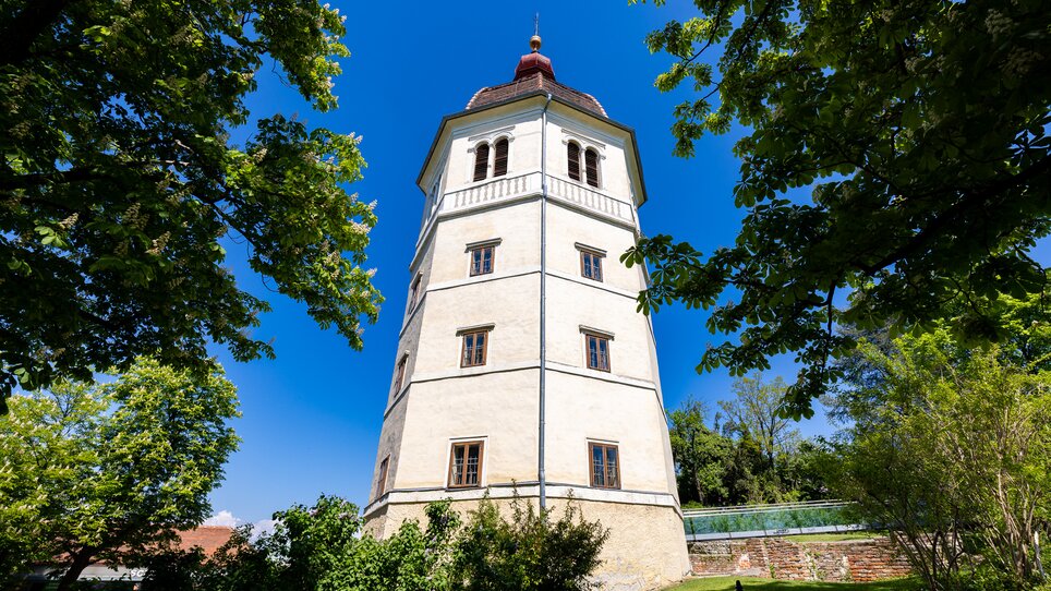 Ein Blick auf den Glockenturm am Grazer Schlossberg, umgeben von Bäumen. | © Graz Tourismus - Harry Schiffer