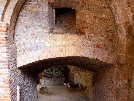 Un portale gotico sullo Schlossberg a Graz, circondato da pietre e vecchie mura. | © Graz Tourismus - Harry Schiffer
