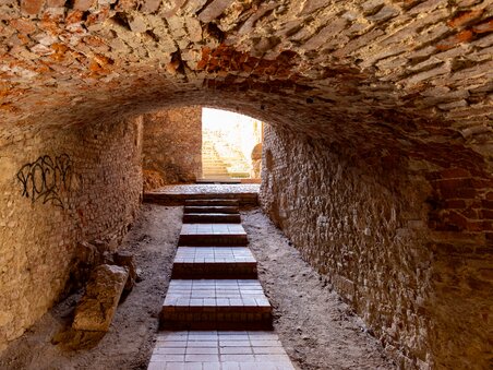 Vista attraverso un tunnel storico con scale verso la luce. | © Graz Tourismus - Harry Schiffer