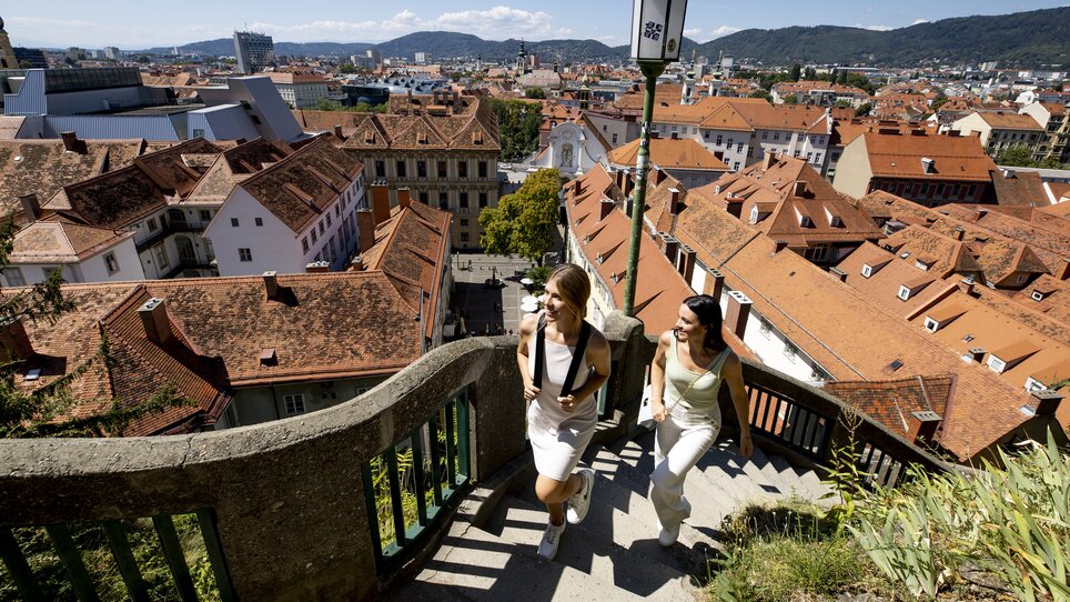 Zwei Frauen steigen den Schlossbergsteig in Graz hinauf. | © Graz Tourismus - Tom Lamm