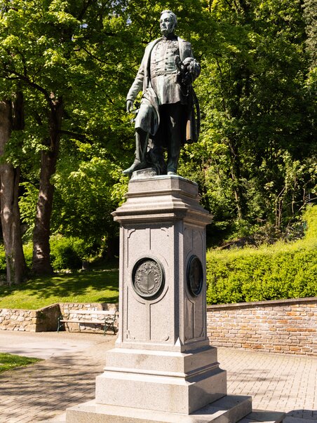 Statua di Welden sullo Schlossberg a Graz, circondata da alberi. | © Graz Tourismus - Harry Schiffer