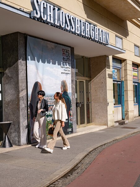 Two women in front of the entrance to the valley station of the Schlossberg Funicular in Graz. | © 5komma5sinne - Rene Strasser