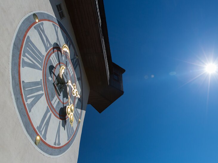 The clock tower of Graz against a bright blue sky. | © Graz Tourismus - Harry Schiffer