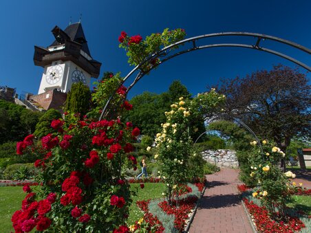 The clock tower on the Schlossberg in Graz, surrounded by a blooming garden. | © Graz Tourismus - Harry Schiffer