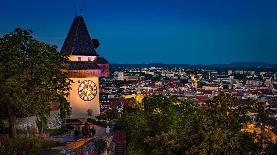 Grazer Uhrturm mit Blick auf die Stadt Graz bei Nacht. | © Graz Tourismus - Werner Krug