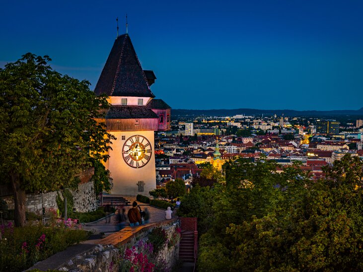 Grazer Uhrturm mit Blick auf die Stadt Graz bei Nacht. | © Graz Tourismus - Werner Krug