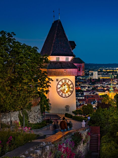 Torre dell'Orologio di Graz con vista sulla città di notte. | © Graz Tourismus - Werner Krug