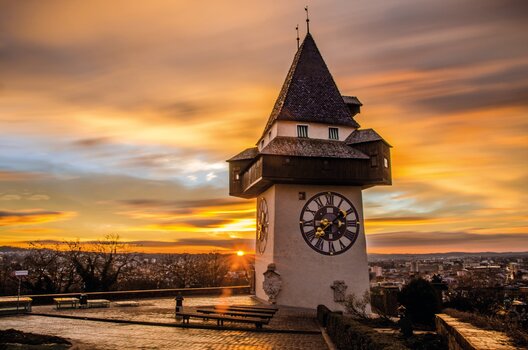 Der Grazer Uhrturm bei Sonnenuntergang über Graz. | © Graz Tourismus - Markus Spenger