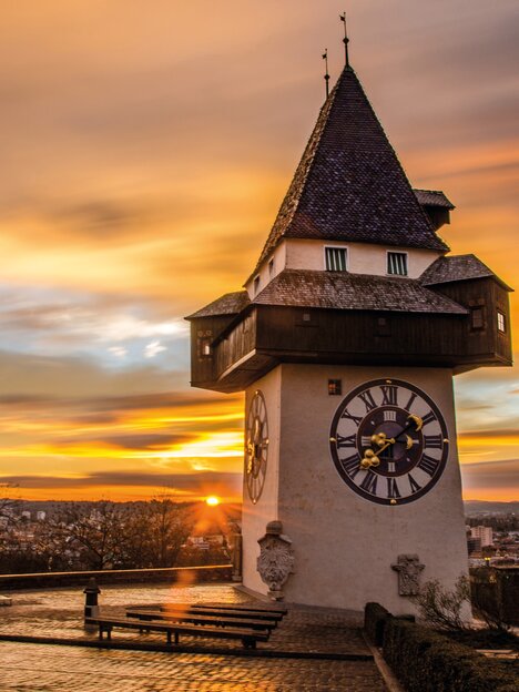 Der Grazer Uhrturm bei Sonnenuntergang über Graz. | © Graz Tourismus - Markus Spenger