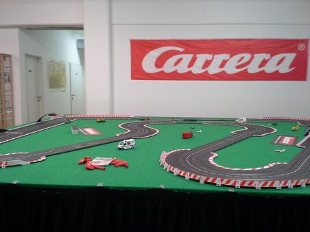 Carrera model racing track with cars on a green surface. | © GATE-08 Flight & Racing Simulation Center e.U. / Herr Marc Asplanato