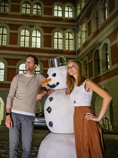 Couple with a snowman in the courtyard of the Priest Seminary during a guided evening tour in Graz. | © Graz Tourismus - Werner Krug