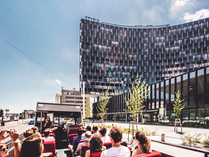 Offene Stadtrundfahrt in Graz mit Blick auf das moderne Gebäude STYRIA. | © Holding Graz -Lupi Spuma