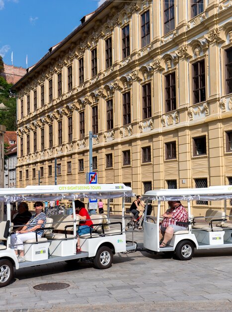 Ein Elektroshuttle auf einer Stadttour in Graz, mit Passagieren. | © Graz Tourismus - Harry Schiffer