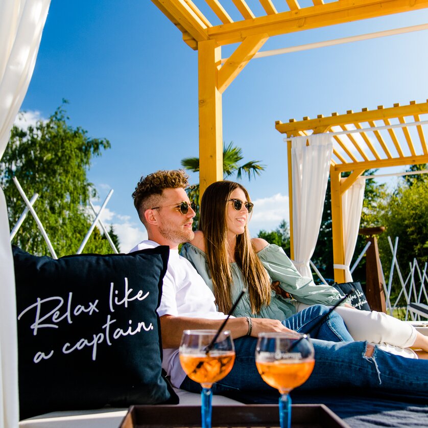 Copacabana | © Region Graz - Mias Photoart Couple relaxing in a lounge with cocktails and a cushion message. | © Region Graz - Mias Photoart