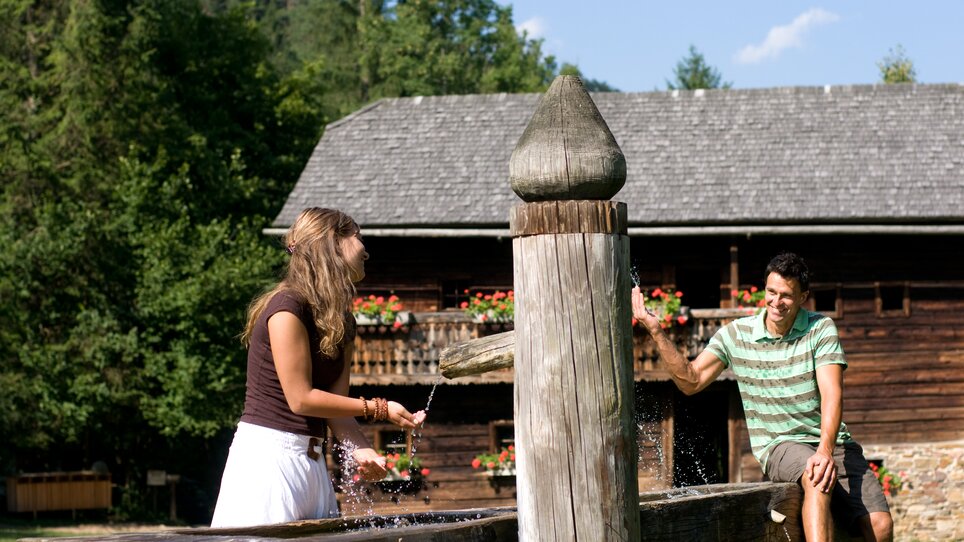 Zwei Personen im Freilichtmuseum Stübing beim Spielen mit Wasser. | © Region Graz - Hans Wiesenhofer