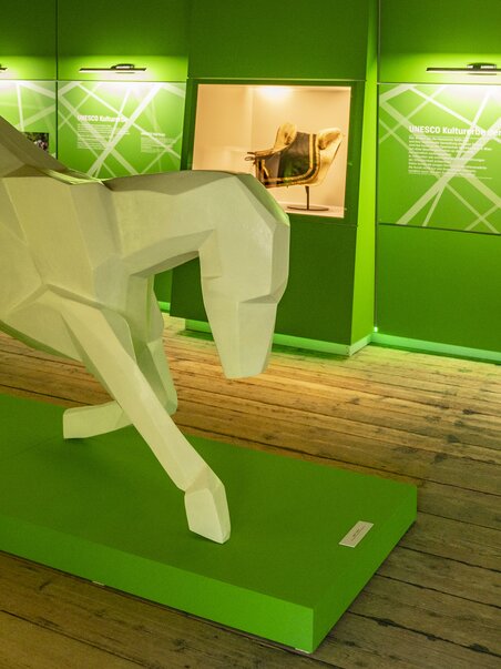 Skulptur eines Pferdes aus geometrischen Formen vor grüner Wand. | © SHS-LipizzanergestütPiberGöR - Renè van Bakel
