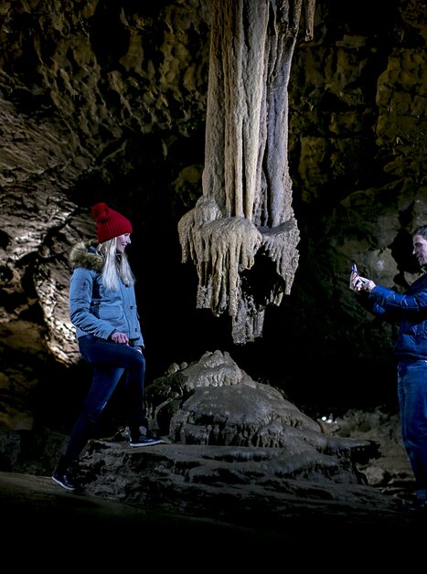 Zwei Personen erkunden die Lurgrotte Peggau, fotografieren Stalaktiten. | © Region Graz - Tom Lamm