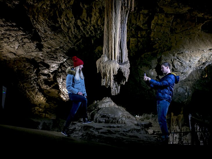 Zwei Personen erkunden die Lurgrotte Peggau, fotografieren Stalaktiten. | © Region Graz - Tom Lamm